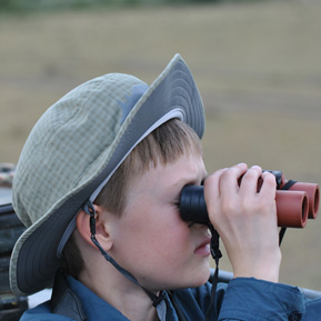 Photo of a Boy looking through Binoculars
